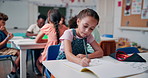 Writing, notebook and education with girl in classroom for future, lesson and students. Learning, academy and knowledge with kid at school for child development, studying and scholarship assessment