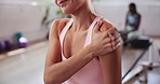 Woman, hands and shoulder pain with injury at gym for muscle tension, sprain or pressure at health club. Closeup, female person or athlete with sore joint, ache or inflammation for fitness strain