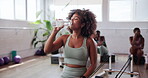Woman, drinking water and pilates break at gym, sports drink and hydration for wellness at club. Workout, person and aqua beverage for liquid nutrition, rest and thirsty recovery with electrolytes