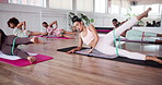 Exercise class, legs and resistance band with people in studio for fitness or training together. Challenge, pilates and tension with personal trainer in group session at gym for strength workout