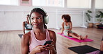 Headphones, pilates and dance with woman in class for streaming, fitness and podcast. Social media, workout and wellness with person and mobile in yoga studio for health, exercise and music app