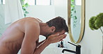 Man, cleaning and mirror with cleanser, skincare with facial hygiene or beauty in morning routine. Anti aging cosmetics, cream or person in bathroom with basin, water splash or face treatment in home