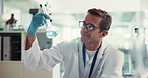 Chemical, man and scientist with glass beaker in laboratory for solvent experiment, research or test. Discovery, professional and male biologist with liquid for chemistry innovation with formula.