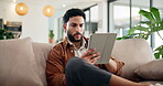 Typing, relax and tablet with man on sofa for social media post, reading and online update. Networking, newsletter subscription and connection with person in living room at home for chat and scroll