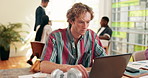 Creative man, designer and typing with laptop for web design, planning or project at office desk. Male person, employee or browsing with computer for schedule, UI or UX interaction at workplace