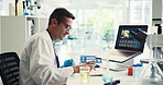 Typing, scientist and man with laptop, lab and medical research for test results or data collection. Healthcare, person and investigation for cure of HIV infection, science and online for treatment