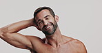 Skincare, smile and face of man in studio for natural, health and facial routine for glow. Portrait, confident and male person from Brazil with hydration dermatology treatment by white background.