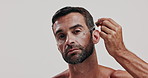 Skincare, hydration and face of man with serum in studio for natural, health and facial routine for glow. Portrait, confident and person with moisturizing dermatology treatment by white background.