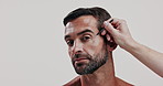 Skincare, hand and face of man with tweezers in studio for natural, epilation and facial routine for glow. Portrait, confident and male person with eyebrow hair removal treatment by white background.