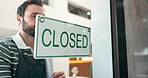 Waiter, man and closed sign by cafe door for end of day, no service and message to public. Storefront, signage poster and barista with info on glass for restaurant notice and customer advertisement
