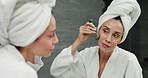 Mirror, cosmetics and woman with rose quartz, house and lymphatic drainage with skincare. Bathroom, reflection and mature person with jade roller, anti aging or facelift with massage for collagen