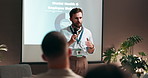 Businessman, presentation and screen with mic for convention, conference or group seminar at office. Male person, speaker or speech with audience for mental health training or wellbeing at workshop