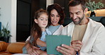 Tablet, education and parents with daughter on sofa for elearning, teaching app and support. Helping, online tutor and kindergarten lesson with man, woman and child in living room of family home