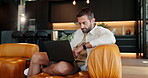 Relax, laptop and typing with man on sofa for streaming service, online review or show rating. Subscription network, search and connection with person in living room at home for entertainment website