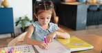 Little girl, drawing or book with color for homework, fun activity or creativity on table at home. Child, kid or student learning with textbook for creative project, assignment or assessment at house