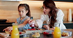House, mother and girl in kitchen, pancakes and help with child development, nutrition and wellness. Family, parent and mama with daughter, orange juice and bonding together with breakfast and food