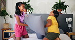 Happy, playing and children on bed for pillow fight, bonding and sister relationship in morning. Family home, siblings and girls in bedroom for laughing, having fun and playful together for childhood