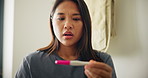 Asian woman, pregnancy test and surprise with stress, worry or concern with fear. Japanese person, pregnant or girl with reaction, confused or maternity with depression, overwhelmed or regret in home