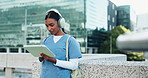 Headphones, doctor and woman student with tablet in city studying for clinical exam or test. Education, technology and female healthcare intern listening to music and reading online textbook in town