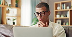 Laptop, glasses and man on sofa in home reading email for university scholarship application. Technology, research and male student study in living room for college admission test, exam or assignment