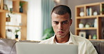 Laptop, serious and man on sofa in home reading email for university scholarship application. Technology, research and male student study in living room for college admission test, exam or assignment