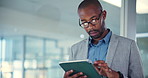 African man, tablet and typing at office in hallway for research, insight and decision with lead for article. Person, writer and journalist with application by window, review and info for newsletter