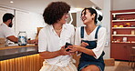 Talking, friends and laughing with phone in cafe for funny post, social media meme or online gossip. Gen z people, happy and smartphone in restaurant for internet news, bonding together or connection
