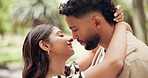 Love, hug and couple kiss in park for bonding, dating and commitment on weekend. Nature, morning and happy man and woman embrace for affection, relationship and anniversary for romance together