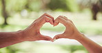 Heart, love and hands of couple outdoor for commitment, connection or support with care. Closeup, romance symbol or people with sign for marriage together, healthy relationship or loyalty to partner