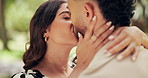 Happy, kiss and couple hug in park for bonding, dating and commitment for outdoor. Nature, love and man and woman embrace for affection, relationship and anniversary for romance on weekend together
