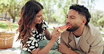 Eating, couple and picnic with pizza in nature for anniversary date, bonding together or romantic kiss. Love, people and relax with lunch at park for sharing fast food, hungry or relationship support