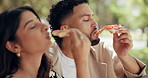 Love, couple and eating a pizza at park for romantic date, bonding together and anniversary celebration. Hungry, people and toast fast food in nature for loyalty, conversation or relationship support