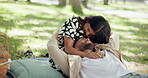 Couple, date and laugh in park with tickle, bonding and funny joke. Happy people, commitment and laying outdoor for relationship development, weekend relax or smile for love and anniversary picnic