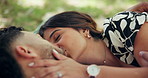 Love, couple and kiss outdoor on picnic, connection and relax together on date for chat. Man, woman and romance at park for relationship, marriage or support with partner on vacation with happiness