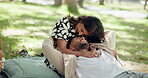Romance, hug and couple on picnic, park and bonding for anniversary in nature, love or conversation. Outdoor, embrace and people with smile on date, relax and commitment in relationship, happy or joy