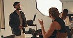 Photography, tablet and production with man in studio for talking, creative director and backstage process. Magazine media, photoshoot and catalog idea with team of people on set for project