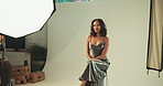 Photography, set and woman on stool in studio with production team for creative magazine. Fashion, equipment and gen z female influencer model posing on chair for portfolio photoshoot with art agency