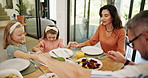 Children, praying and holding hands at lunch in family home with food, bonding and faith with smile. Parents, kids and gratitude with religion, love and connection with diet at Easter in dining room