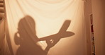 Tent, home and girl with airplane, games and playing with toys, daydreaming and happiness. Apartment, kid and childhood in living room, mockup space and cheerful with shadow, relaxing and fantasy