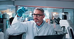 Scientist, mature man and chemical with microscope testing for chemistry, study or medical research. Biotech, laboratory and analysis with liquid inspection for pharmaceutical or pathology experiment
