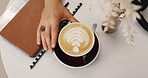 Latte art, notebook and hands of person in cafe with cup for lunch break, remote work and beverage. Cafeteria, freelance and above of espresso with closeup of customer in coffee shop for hospitality