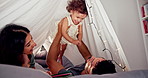 Tent, parents and playing with baby in home for bonding together, flying game and connection with trust. Story book, people and fun activity with child in blanket fort for happy relationship and love