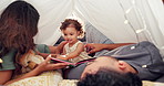 Home, parents and baby with book, relax and smile with love, bonding together and tent. Family, apartment and mother with father, break and child in living room, cheerful and happiness with story