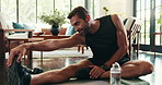 Home, man and legs with stretching for fitness, physical activity and wellness with morning routine. House, male person and warm up with balance for exercise, workout or smile for endurance in lounge