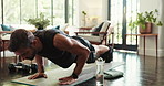 Health, fitness and man with push ups in home for morning workout in living room with challenge. Sports, balance and person with training routine for core strengthening exercise on yoga mat in house.