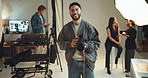 Camera, photographer and smile with man on set for fashion magazine or style photoshoot. Camera, direction or production with photography person behind the scenes for artistic or creative catalog