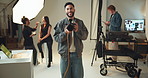 Camera, face and photography with playful man on set for fashion magazine or style photoshoot. Camera, direction or production with smile of photographer behind the scenes for artistic catalog