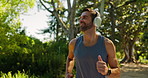 Running, smile and man with headphones, outdoor or routine with music in nature, training or exercise. Active, runner and person with playlist for fitness, workout or practice for marathon in morning