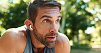 Tired, runner and man with earphones, outdoor and workout for athlete in nature, break or breathing. Exhausted, routine and person with music for exercise, fitness and practice for marathon or sports