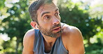 Tired, runner and man with earphones, breathing and workout for athlete in nature, break or outdoor. Exhausted, routine and person with music for exercise, fitness and practice for marathon or sports